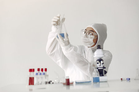 A laboratory scientist is examining blue solution in a bottle