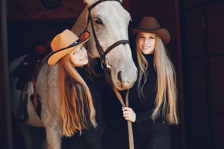 Elegant girls with a horse in a ranchの写真素材