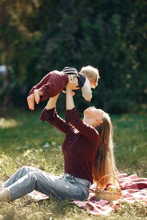 Family in a summer park. Mother in a red sweater. Cute little boyの写真素材