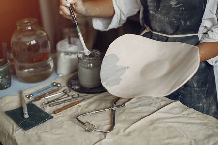 A young woman makes dishes in a potteryの写真素材