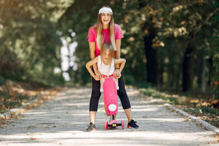 Mother with daughter playing in a summer parkの写真素材