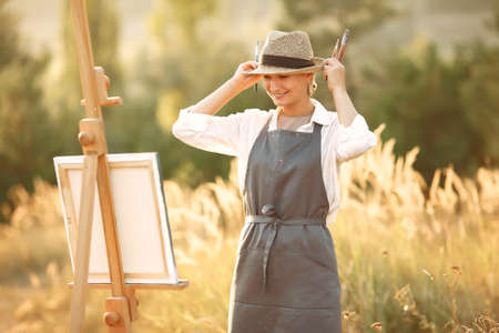 Woman in a apron painting in a fieldの写真素材