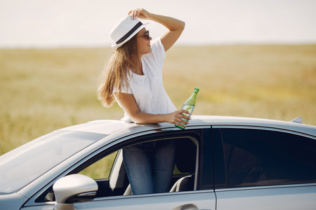 Elegant woman standing bin a hatch of the car