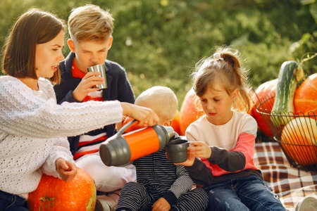 Big family sitting on a garden near many pumpkinsの写真素材