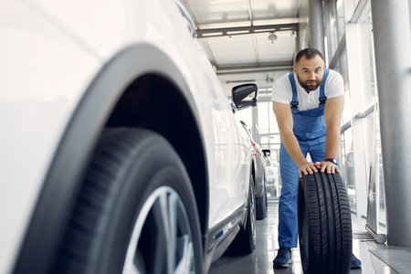 Handsome man in a blue uniform checks the car