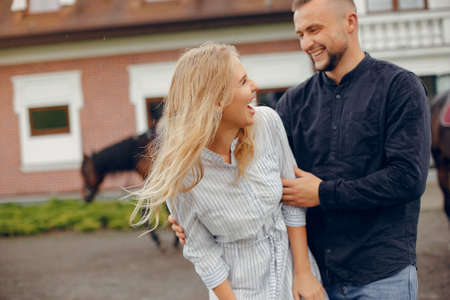 Cute loving couple with horse on ranchの写真素材