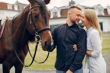 Cute loving couple with horse on ranchの写真素材