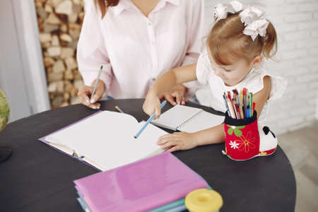 Tutor with litthe girl studying at homeの写真素材