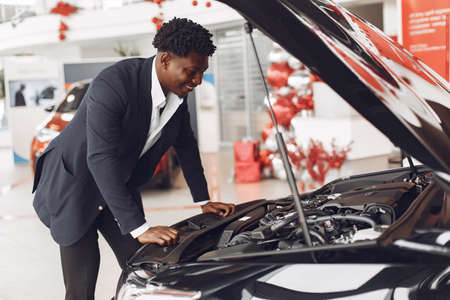 Handsome and elegant black man in a car salonの写真素材