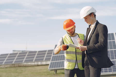 Foreman and businessman at solar energy station.の写真素材