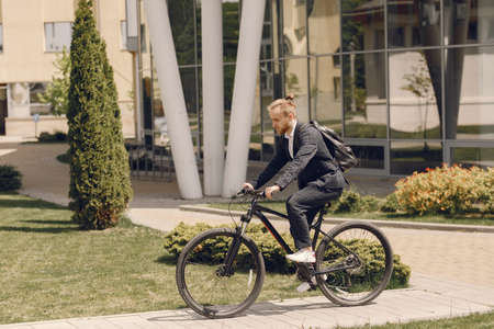 Businessman with bicycle in a summer cityの写真素材