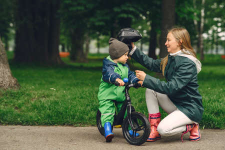 Funny kid in rain boots playing in a rain parkの写真素材