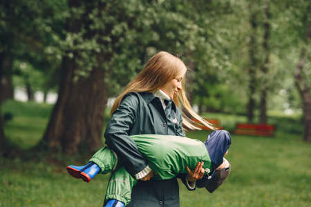 Funny kid in rain boots playing in a rain parkの写真素材