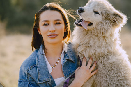 Stylish girl in a spring field with a dog