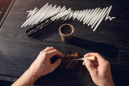 Cropped view of preparing tobacco for shisha on table outside