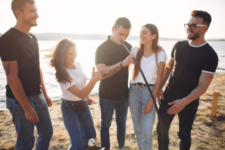 Young people eating pizza smoking hookah outside