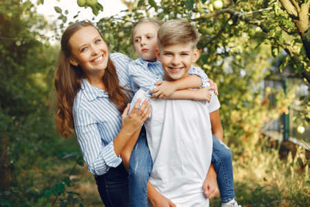 Mother with cute kids in a spring parkの写真素材