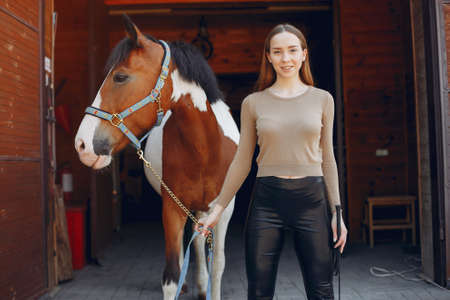 Beautiful woman standing with a horseの写真素材
