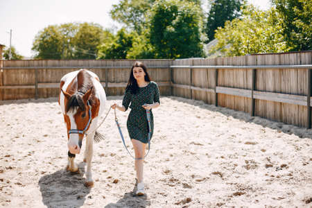 Beautiful woman standing with a horseの写真素材