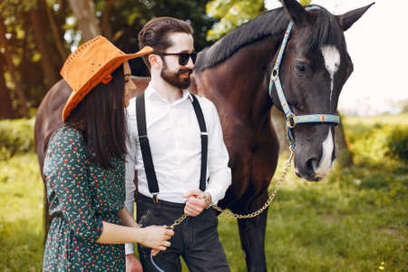Cute loving couple with horse on ranchの写真素材