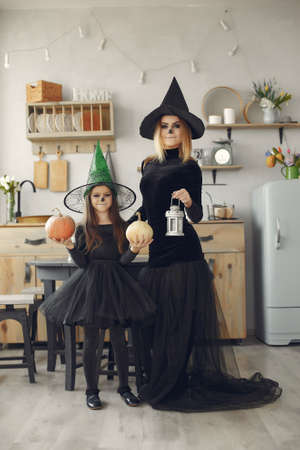Mother with daughter in a halloween costume and makeupの写真素材