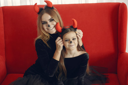 Mother with daughter in a halloween costume and makeup