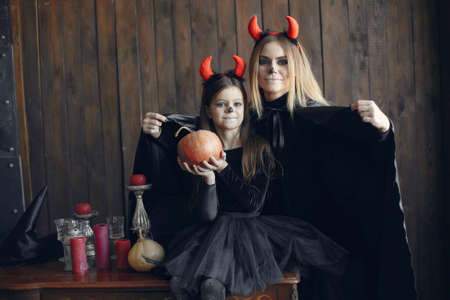 Mother with daughter in a halloween costume and makeupの写真素材