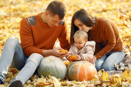 Family with little daughter in a autumn parkの写真素材