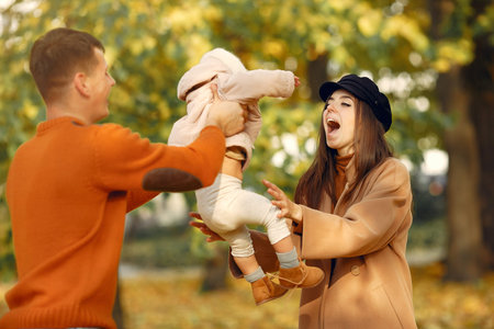 Family with little daughter in a autumn parkの写真素材