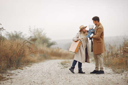 Stylish family walking on a autumn fieldの写真素材