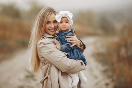 Mother with daughter playing in a autumn fieldの写真素材
