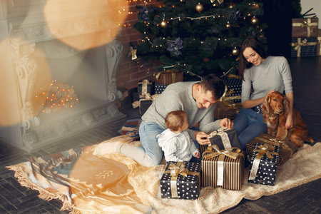 Family with cute dog at home near christmas tree