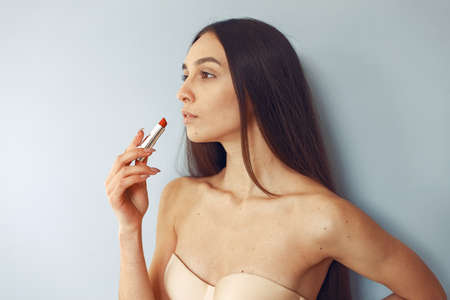 Beautiful girl standing in a studio with red lipstickの写真素材