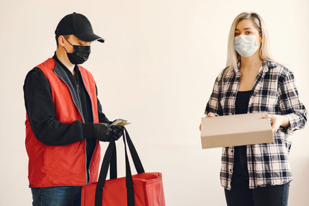 Delivery man in a medic mask with woman