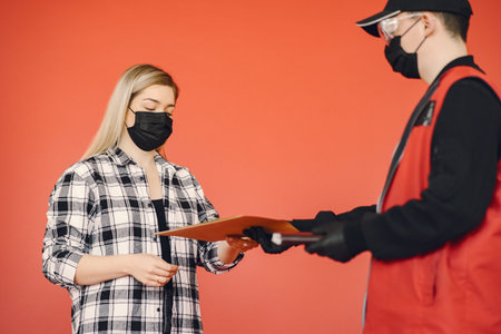 Delivery man in a medic mask with woman