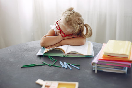 Little girl sitting on a table with books