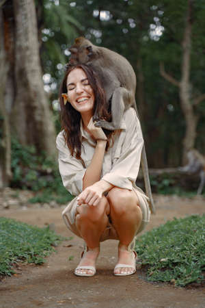 Woman on vacation playing with a monkeyの写真素材