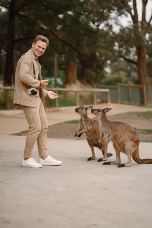 Man in the reserve is playing with a kangarooの写真素材