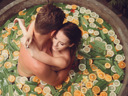 Couple lies in a round bath with fruitsの写真素材