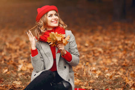 Beautiful woman sitting in a autumn parkの写真素材