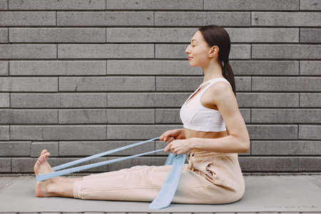 Woman practicing advanced yoga against a dark urban wallの写真素材