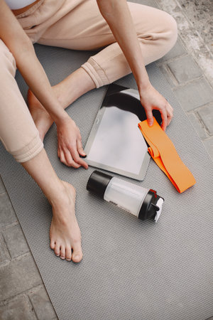 Woman practicing advanced yoga against a dark urban wall