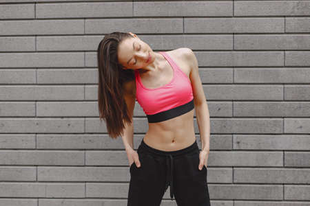 Woman practicing advanced yoga against a dark urban wallの写真素材
