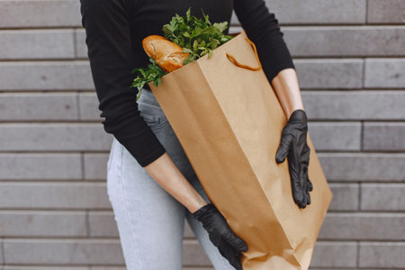 Girl in protective mask holds package with products