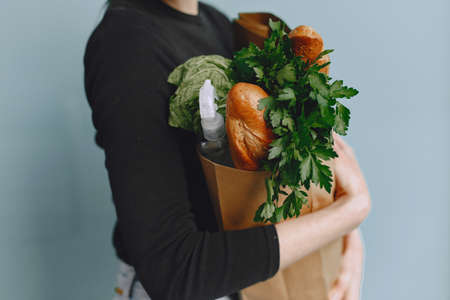 Girl in protective mask holds package with productsの写真素材