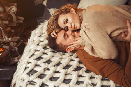 Elegant couple sitting at home near christmas treeの写真素材