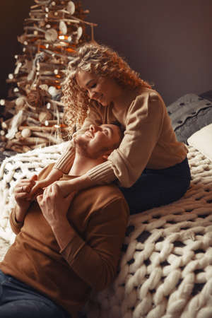 Elegant couple sitting at home near christmas treeの写真素材