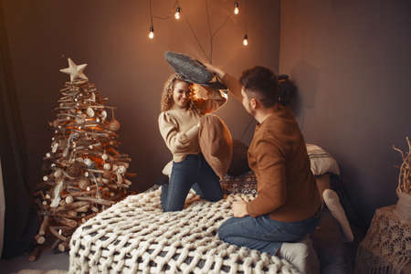 Elegant couple sitting at home near christmas treeの写真素材
