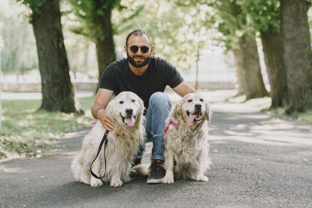 Blind man with guide dog in a summer cityの写真素材