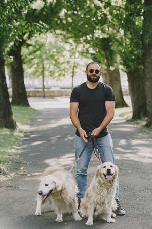 Blind man with guide dog in a summer cityの写真素材